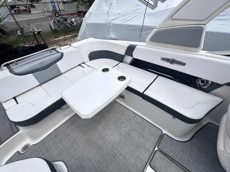 Slide: The Image of 2021 Chaparral 30 Surf boat interior with white seating and table. - 17