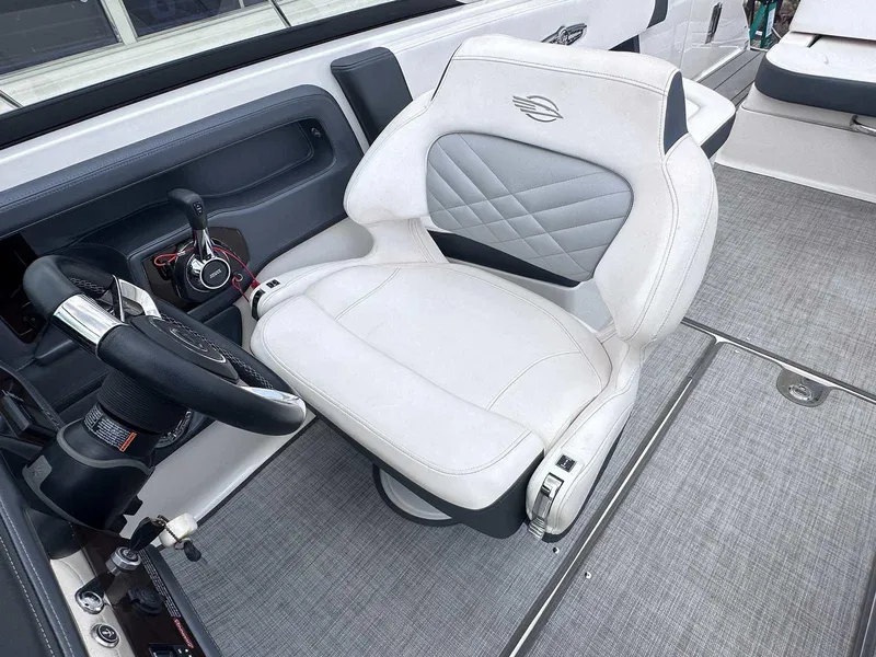 Slide: The Image of Captain's seat in 2021 Chaparral 30 Surf boat, featuring sleek design and modern controls. - 23