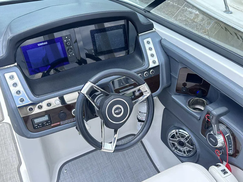 Slide: The Image of 2021 Chaparral 30 Surf boat dashboard with steering wheel, digital displays, and control panel. - 26