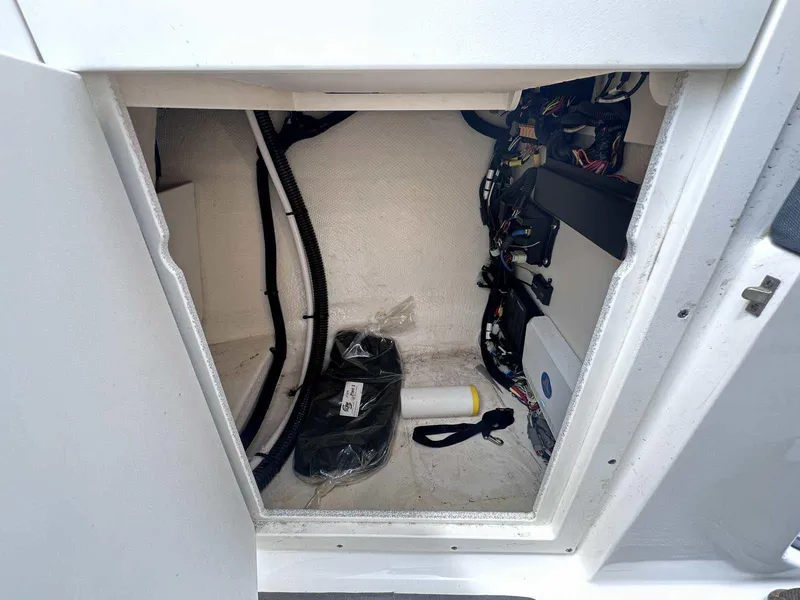 Slide: The Image of Storage compartment of 2021 Chaparral 30 Surf boat, showing cables and equipment. - 32