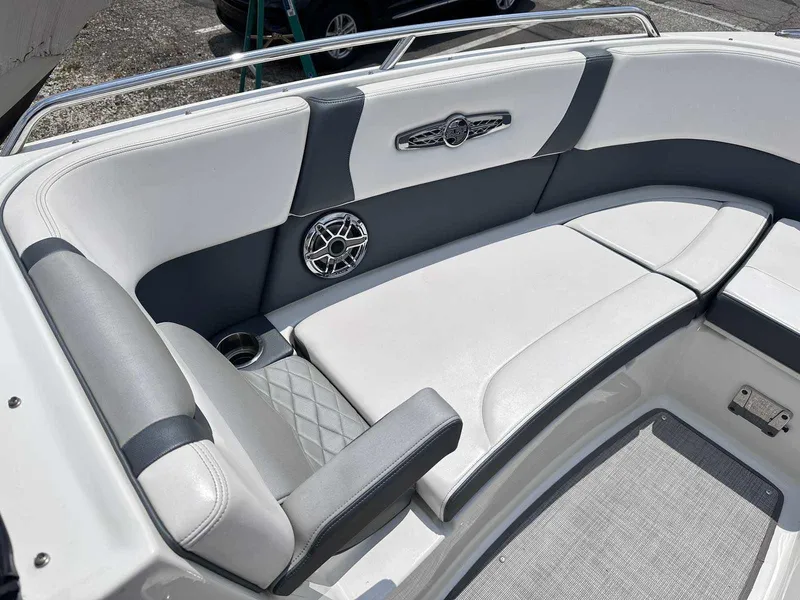 Slide: The Image of 2021 Chaparral 30 Surf boat interior with white and gray seating, speaker, and cup holder. - 35