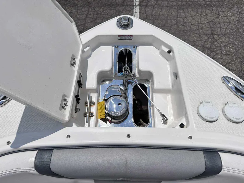 Slide: The Image of 2021 Chaparral 30 Surf boat anchor compartment with open hatch, showcasing storage and equipment. - 41