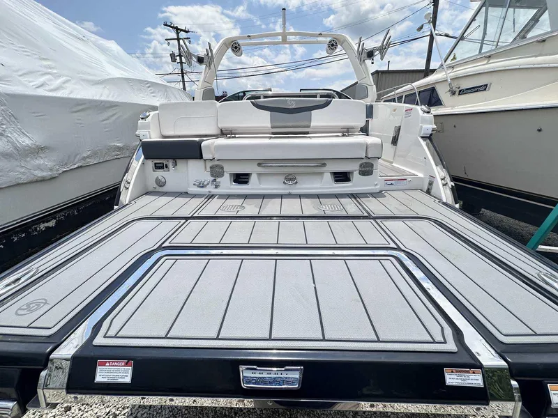 Slide: The Image of 2021 Chaparral 30 Surf boat with spacious deck and modern design, docked outdoors. - 6