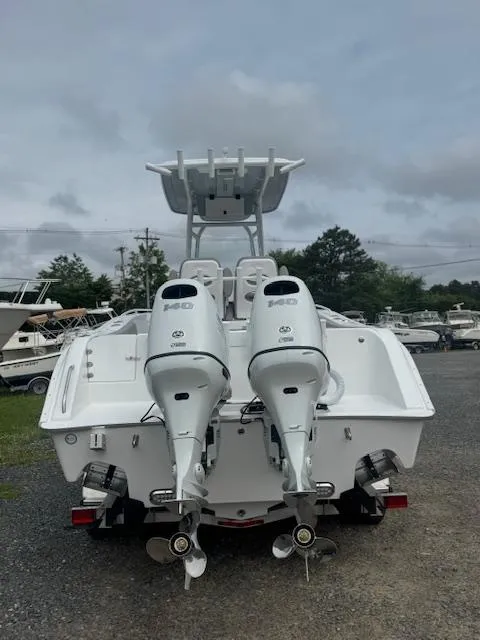 Slide: The Image of 2025 Cape Horn 22 OS boat with dual outboard motors, parked on gravel lot. - 11