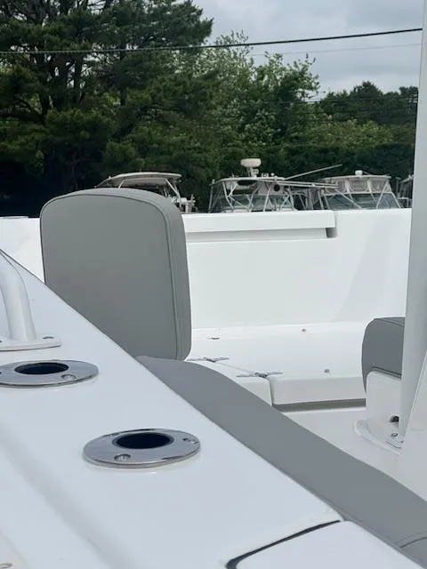 Slide: The Image of 2025 Cape Horn 22 OS boat interior with seating and rod holders, surrounded by trees. - 15