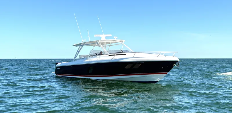 The Image of 2012 Intrepid 400 Cuddy boat on open water under clear blue sky. - 0