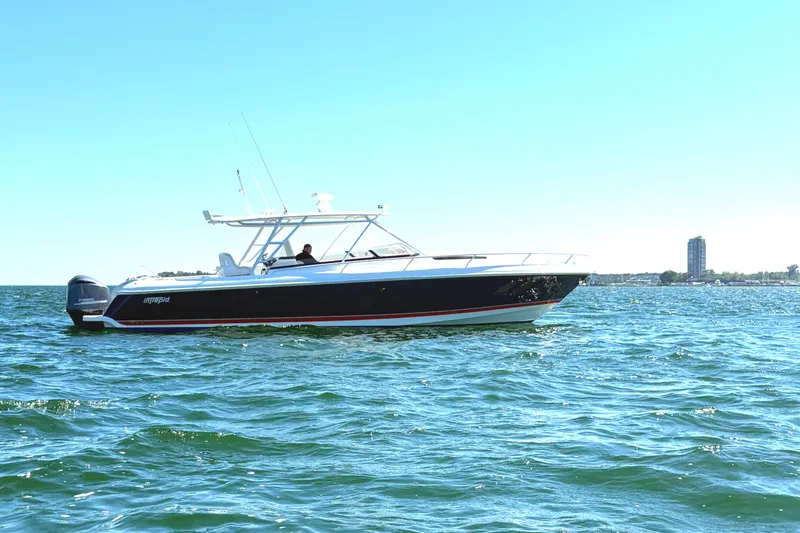 Slide: The Image of 2012 Intrepid 400 Cuddy boat cruising on open water under clear blue sky. - 1