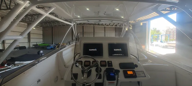 Slide: The Image of Cockpit of 2012 Intrepid 400 Cuddy with Garmin displays in a boat storage facility. - 11