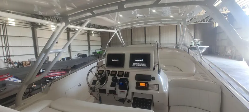 Slide: The Image of 2012 Intrepid 400 Cuddy boat interior with Garmin navigation system in a spacious warehouse. - 13
