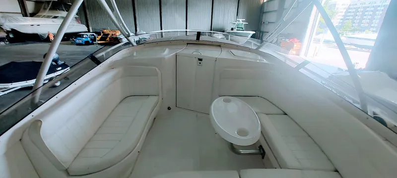 Slide: The Image of 2012 Intrepid 400 Cuddy boat interior with white seating and table in a storage facility. - 20