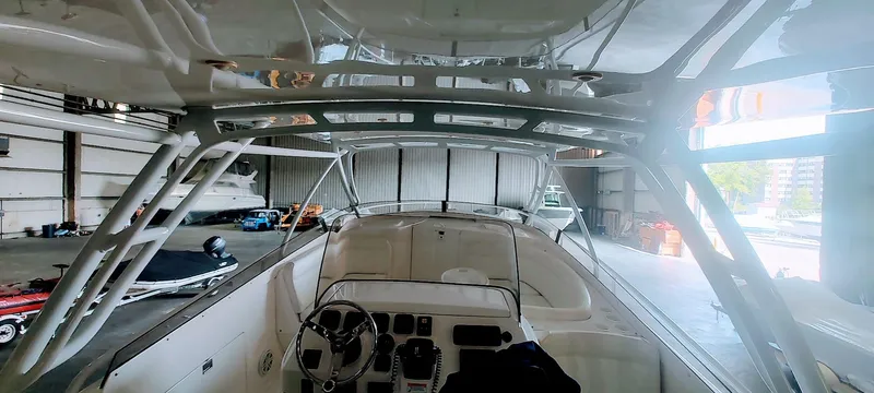 Slide: The Image of 2012 Intrepid 400 Cuddy boat interior in a storage facility, showcasing helm and seating area. - 21