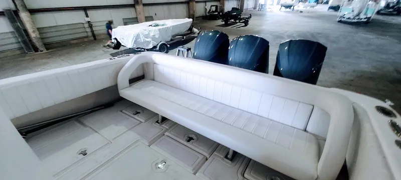 Slide: The Image of 2012 Intrepid 400 Cuddy boat interior with white seating and triple outboard engines. - 22