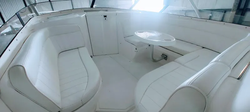 Slide: The Image of 2012 Intrepid 400 Cuddy interior with white seating and table in a spacious cabin. - 25