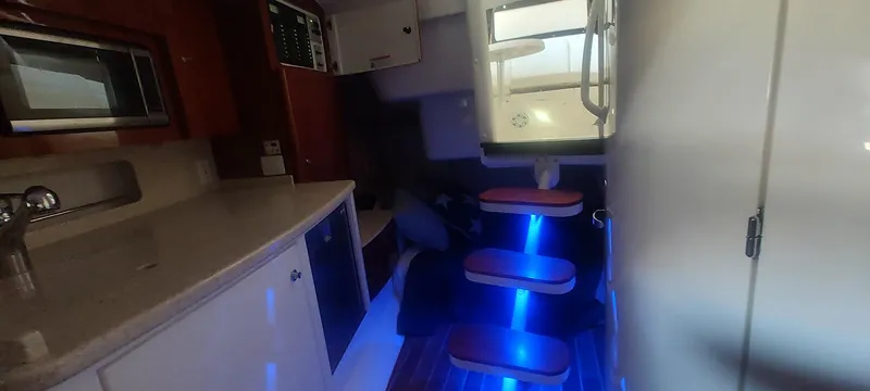 Slide: The Image of Interior of 2012 Intrepid 400 Cuddy with modern kitchen and illuminated stairs. - 31