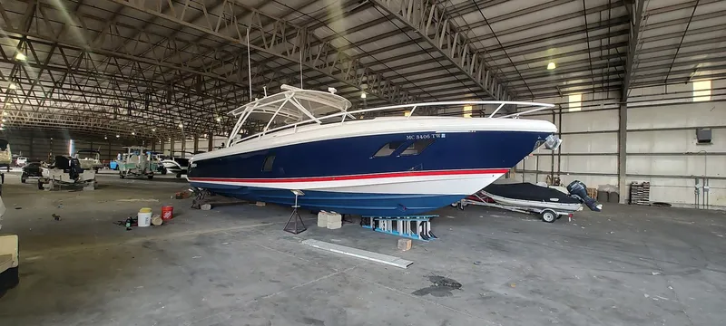 Slide: The Image of 2012 Intrepid 400 Cuddy boat in a spacious indoor storage facility. - 6