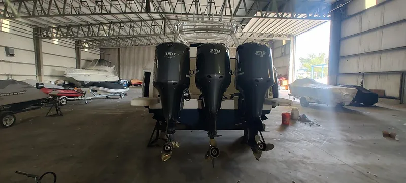 Slide: The Image of 2012 Intrepid 400 Cuddy boat with triple outboard engines in a spacious indoor storage facility. - 9