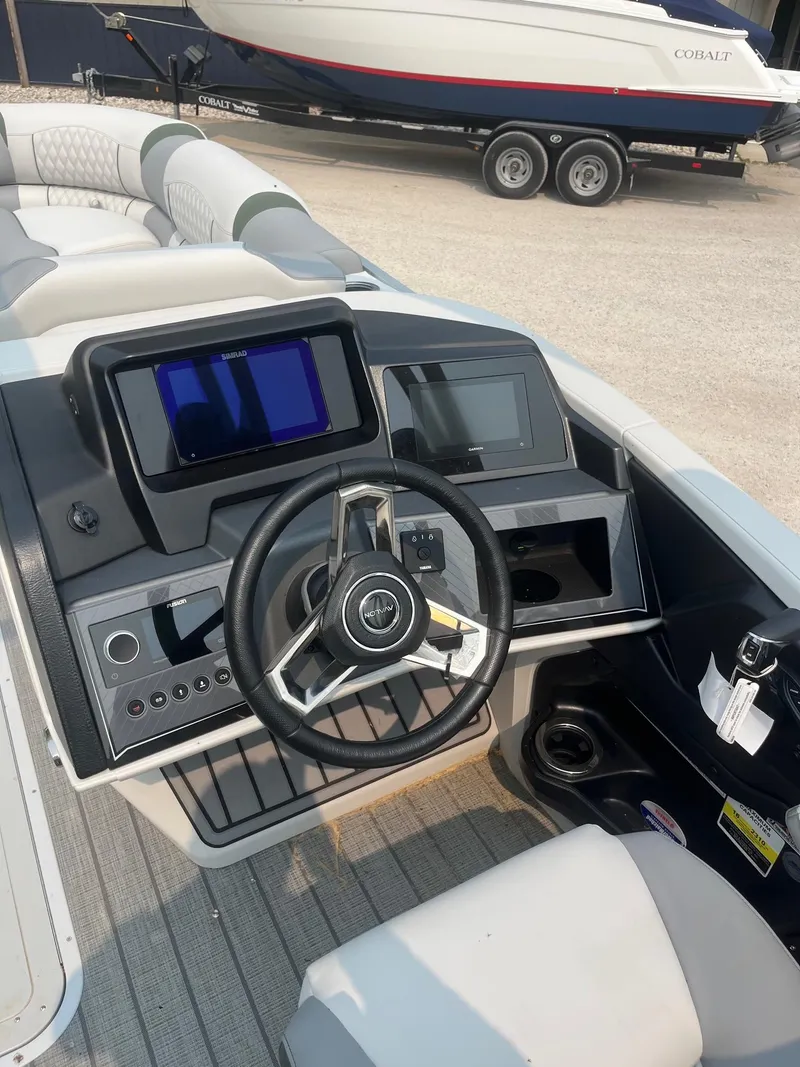 Slide: The Image of 2025 Avalon 2585 Catalina Quad Lounger Shift boat dashboard with steering wheel and navigation screen. - 15