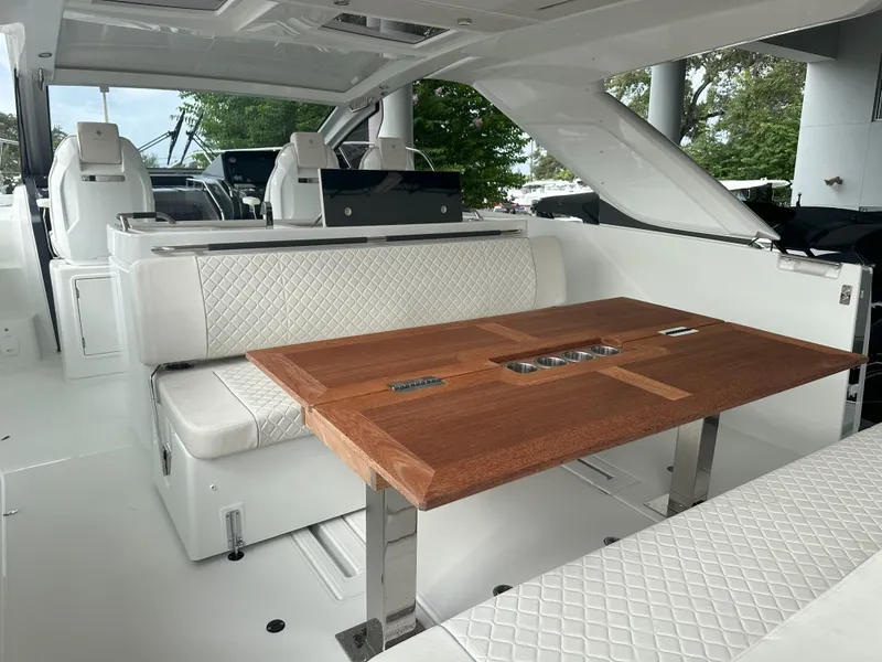 Slide: The Image of 2024 Jeanneau DB 43 yacht interior with elegant wood table and white quilted seating. - 15