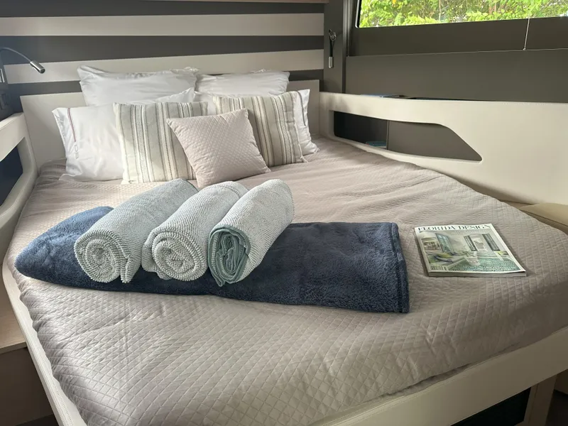 Slide: The Image of Luxurious cabin interior of 2024 Jeanneau DB 43 yacht with neatly arranged towels and magazine. - 31