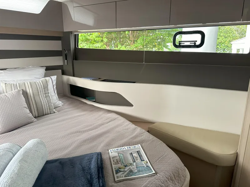 Slide: The Image of 2024 Jeanneau DB 43 cabin interior with bed, window, and modern design elements. - 35