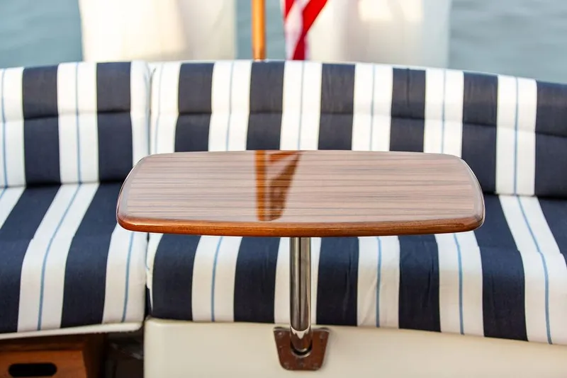 Slide: The Image of 2024 Hinckley 35 yacht interior with striped bedding and wooden cabinetry. - 12