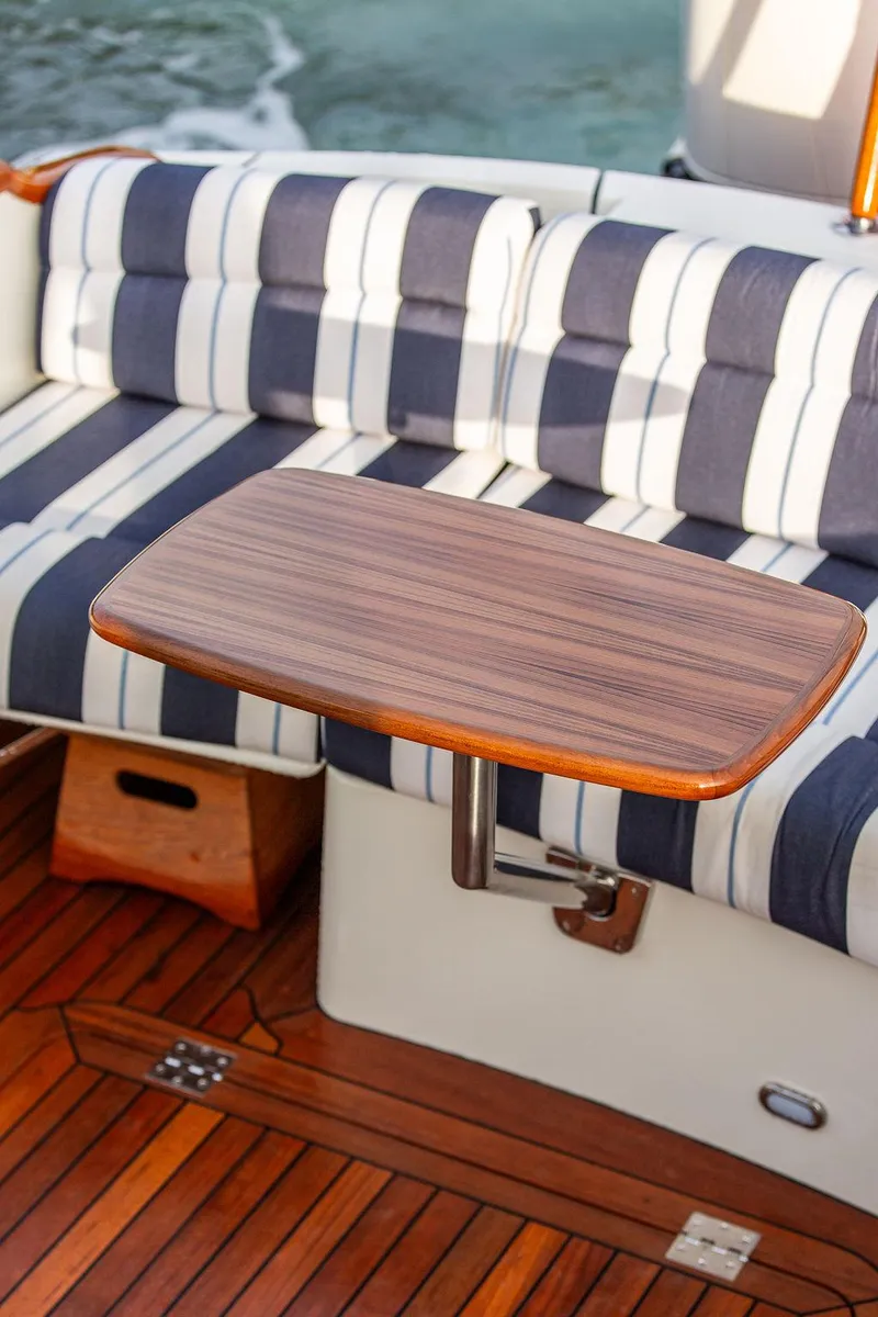 Slide: The Image of 2024 Hinckley 35 yacht interior with striped seating and polished wood finishes. - 14