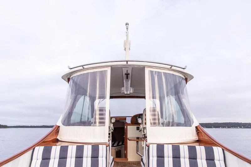 Slide: The Image of Interior of 2024 Hinckley 35 boat with captain's chair and striped seating. - 17