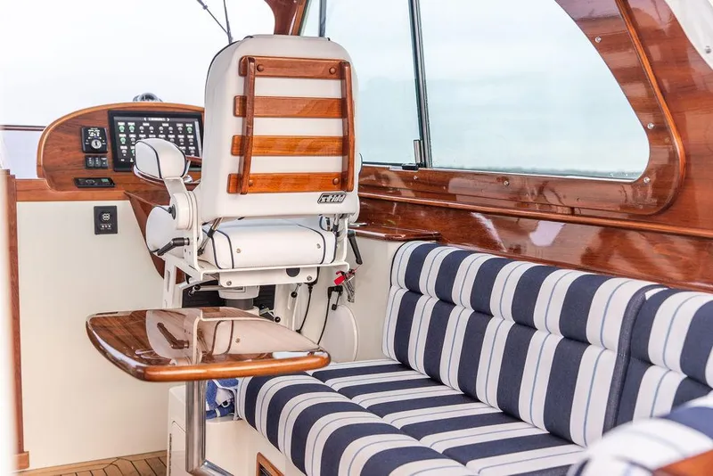 Slide: The Image of Steering wheel of 2024 Hinckley 35 boat, featuring polished wood and metal design. - 19