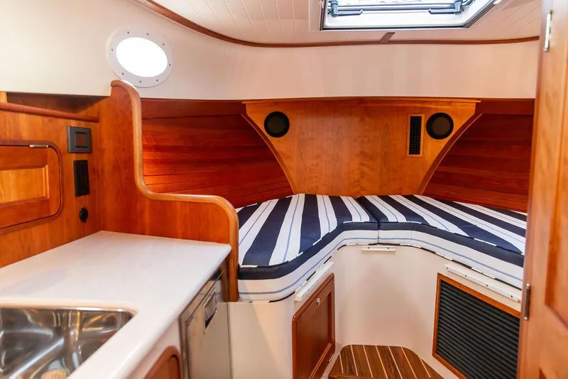 Slide: The Image of 2024 Hinckley 35 helm with wooden steering wheel and advanced navigation controls. - 2