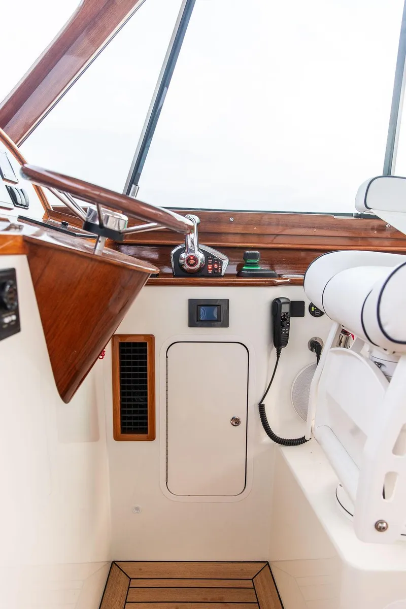 Slide: The Image of 2024 Hinckley 35 helm with wooden steering wheel and navigation display. - 22