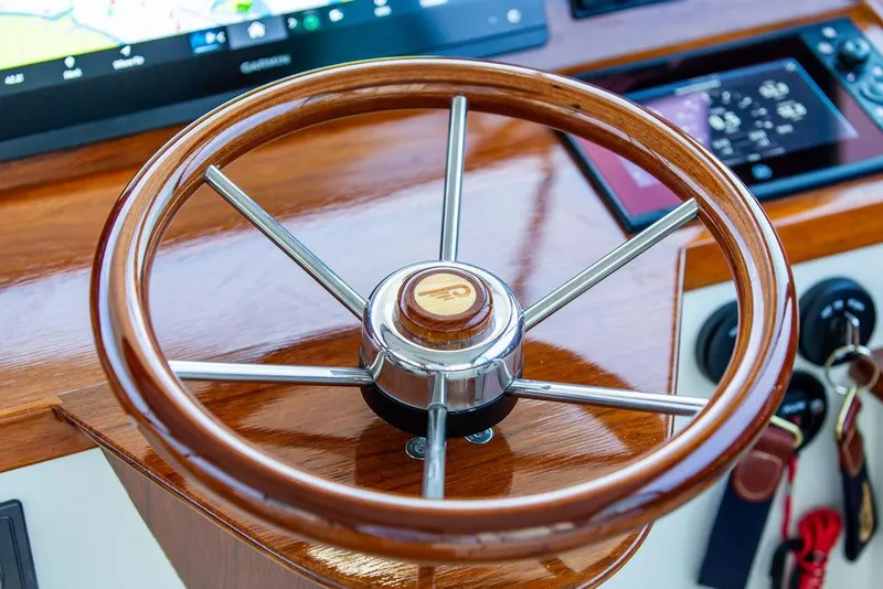Slide: The Image of 2024 Hinckley 35 boat interior with polished wood and modern controls. - 23