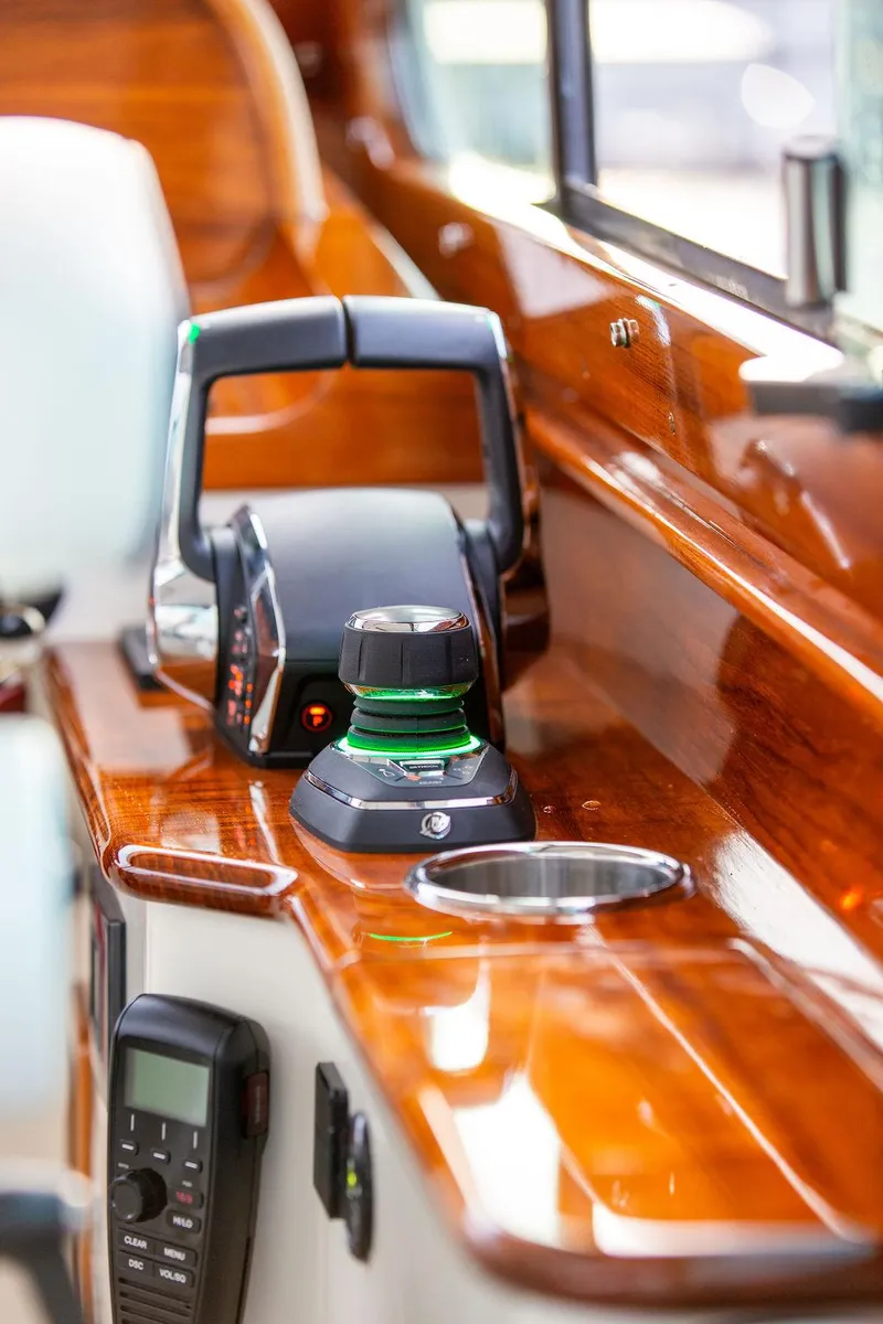 Slide: The Image of 2024 Hinckley 35 boat seat with wooden accents and white upholstery. - 26