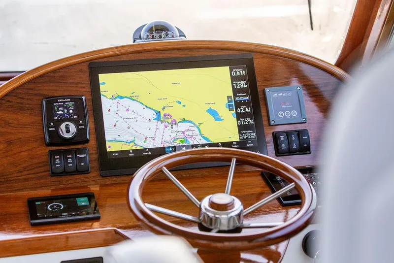 Slide: The Image of 2024 Hinckley 35 boat interior with striped seating and wooden accents. - 28