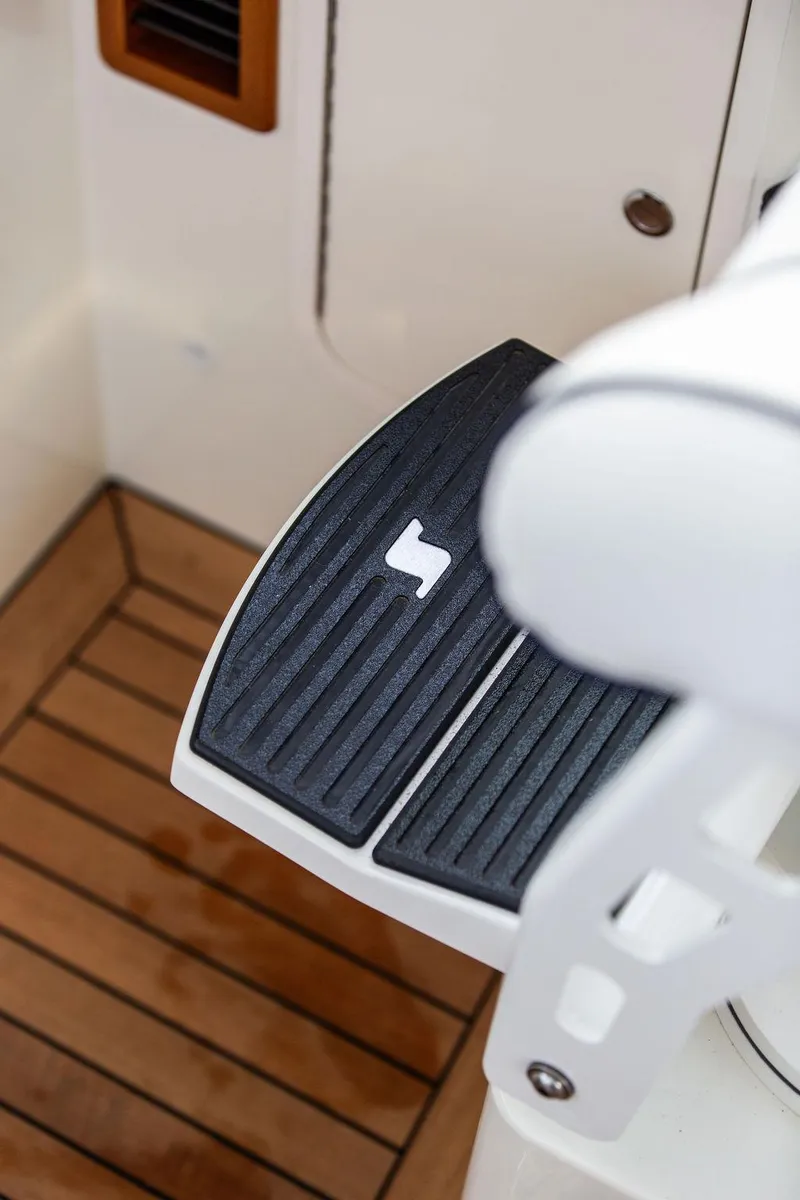 Slide: The Image of 2024 Hinckley 35 interior with striped seating and wooden flooring. - 29