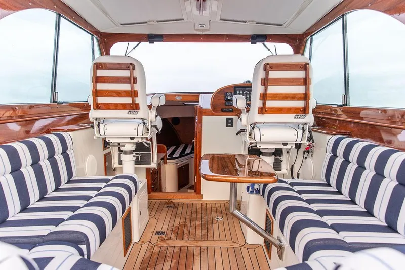 Slide: The Image of 2024 Hinckley 35 yacht interior with striped seating and wooden flooring. - 3