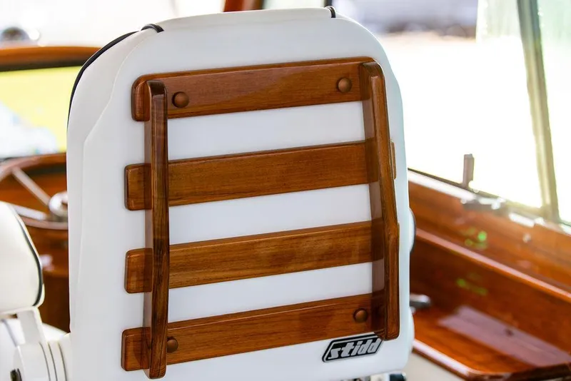 Slide: The Image of 2024 Hinckley 35 yacht with striped seating and clear windows on a calm water backdrop. - 30