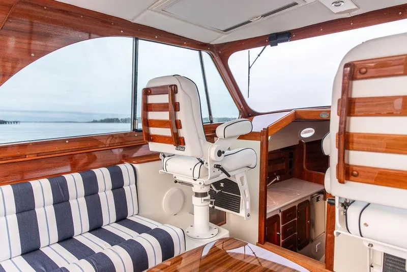 Slide: The Image of 2024 Hinckley 35 yacht interior with striped seating and polished wood accents. - 31
