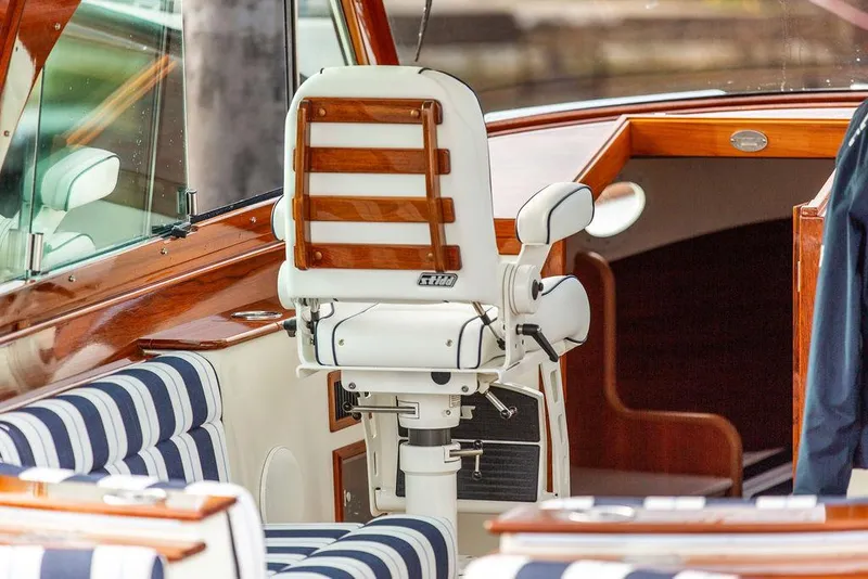 Slide: The Image of 2024 Hinckley 35 yacht interior with striped seating and lake view. - 32