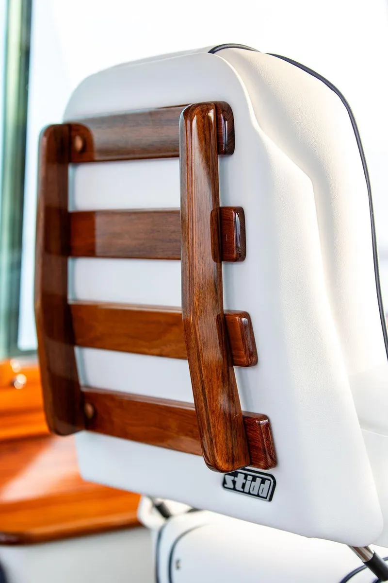 Slide: The Image of Elegant interior of 2024 Hinckley 35 yacht with striped seating and polished wood table. - 33