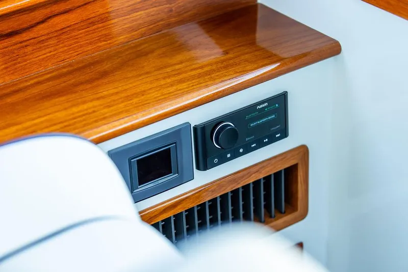 Slide: The Image of 2024 Hinckley 35 boat interior with striped seating and wooden table. - 34