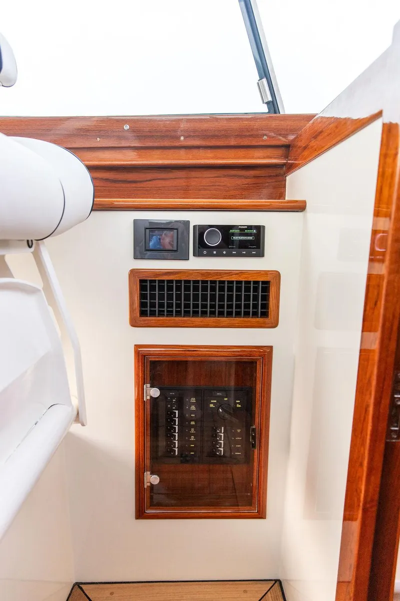 Slide: The Image of Luxury seating area on 2024 Hinckley 35 yacht with striped cushions and wooden table. - 35