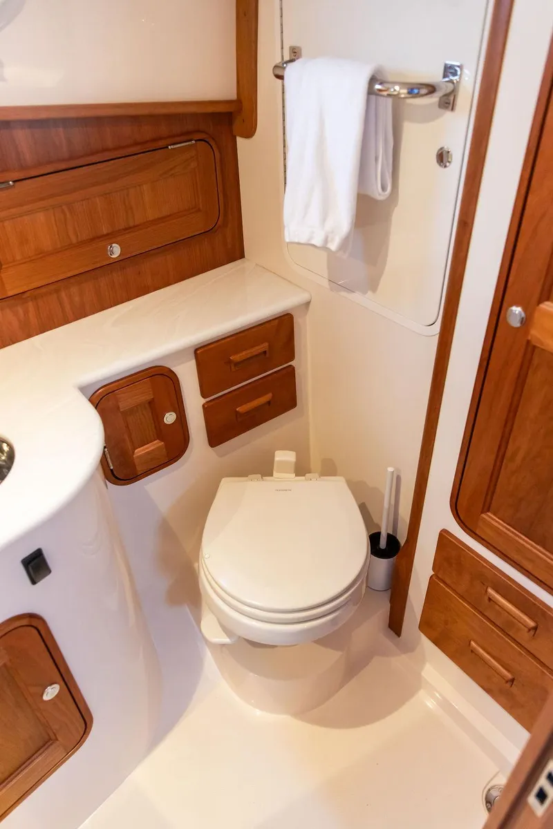 Slide: The Image of 2024 Hinckley 35 yacht interior with modern kitchen, wooden cabinetry, and stainless steel sink. - 4
