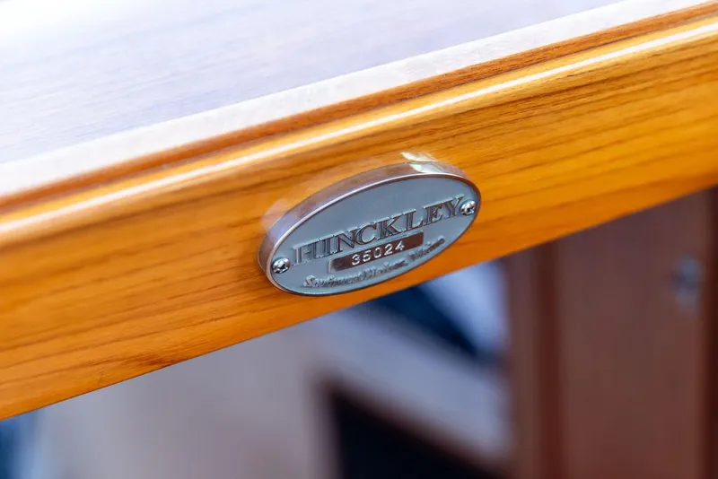 Slide: The Image of 2024 Hinckley 35 yacht interior with wood finish, striped bedding, and compact kitchenette. - 41
