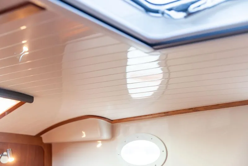 Slide: The Image of 2024 Hinckley 35 yacht interior with wooden cabinetry, sink, and microwave. - 42