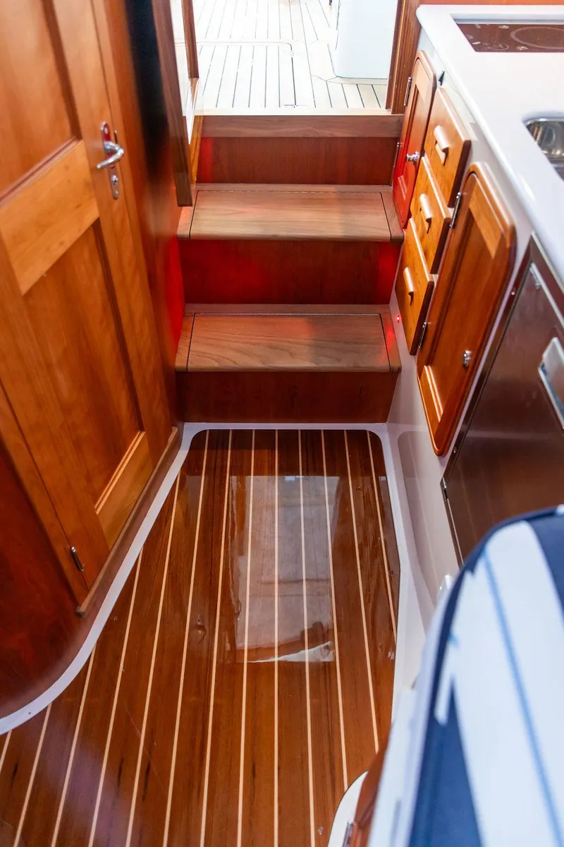 Slide: The Image of 2024 Hinckley 35 yacht interior with modern kitchen, sink, and wooden cabinetry. - 43