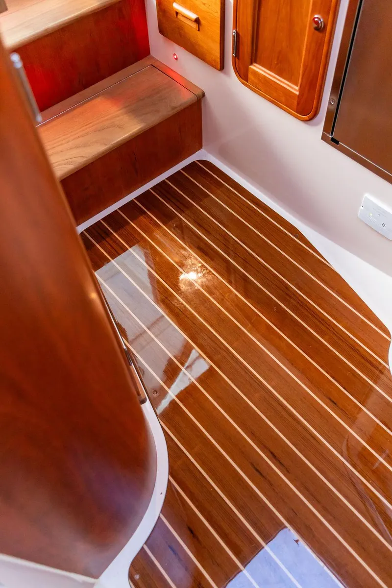 Slide: The Image of 2024 Hinckley 35 yacht interior kitchen with wood cabinetry, stainless steel sink, and modern appliances. - 44