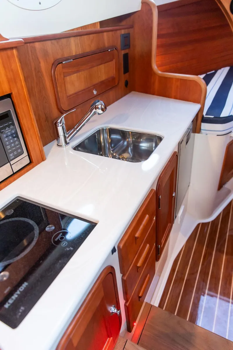 Slide: The Image of 2024 Hinckley 35 boat docked in a serene marina setting. - 48