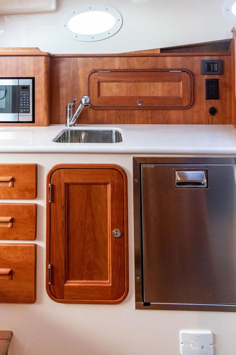 Slide: The Image of Bow of 2024 Hinckley 35 boat with polished wood trim and anchor detail. - 49