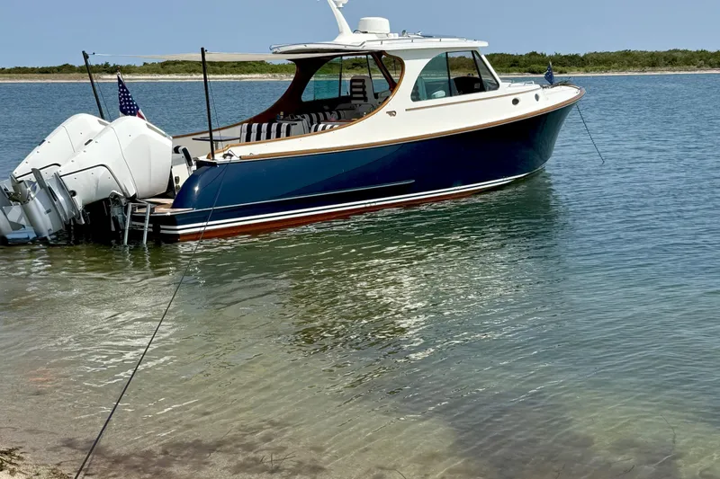 Slide: The Image of 2024 Hinckley 35 boat cruising on calm water with scenic background. - 5
