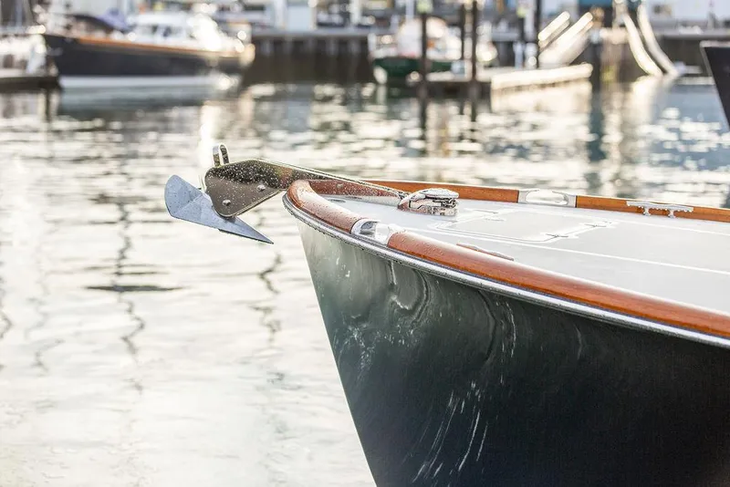 Slide: The Image of 2024 Hinckley 35 boat interior with polished wooden flooring and striped seating. - 56